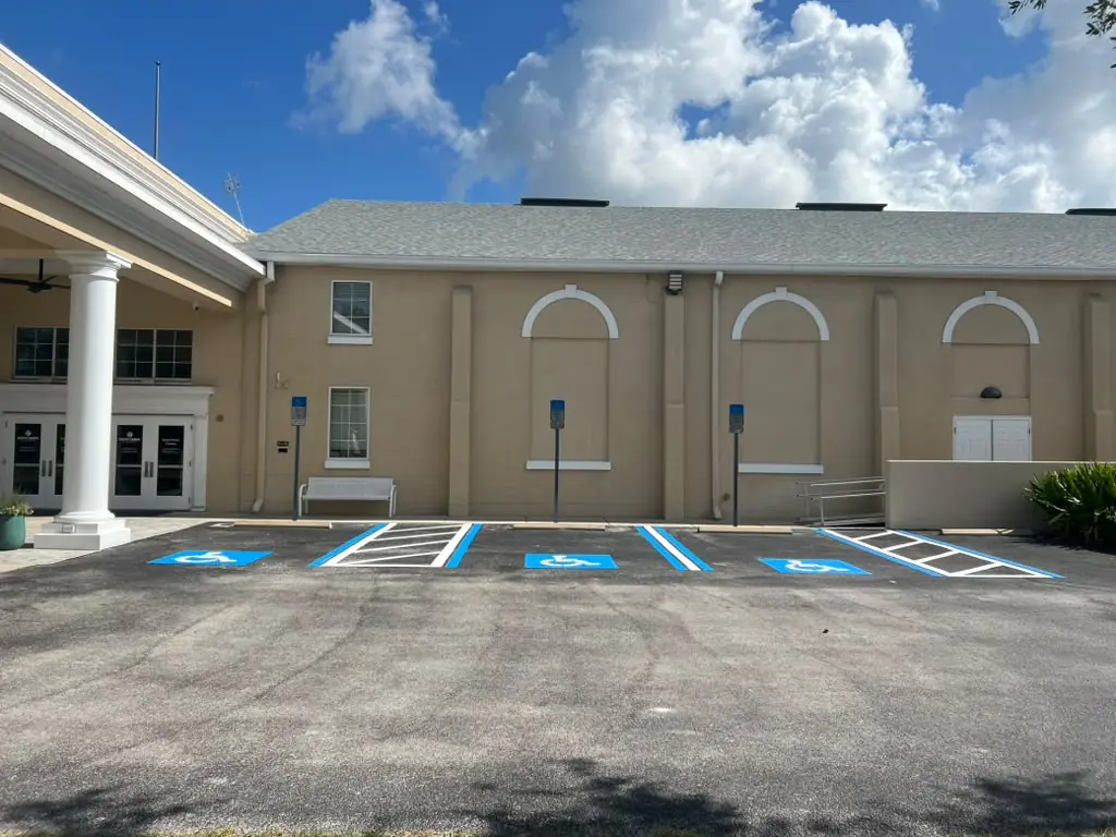 Freshly striped commercial parking lot with new ADA handicap stalls and crisp line striping at a Tampa Bay, Florida property